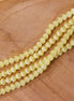 Cat eye glaskralen per streng - butter yellow
