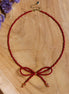 Kralenketting - bordeaux strik goud
