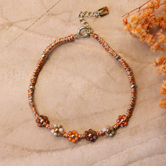 Armband van bruin koord met kralenbloemen