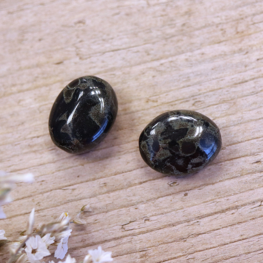 Perle schwarz - oval mit grünen Ölflecken