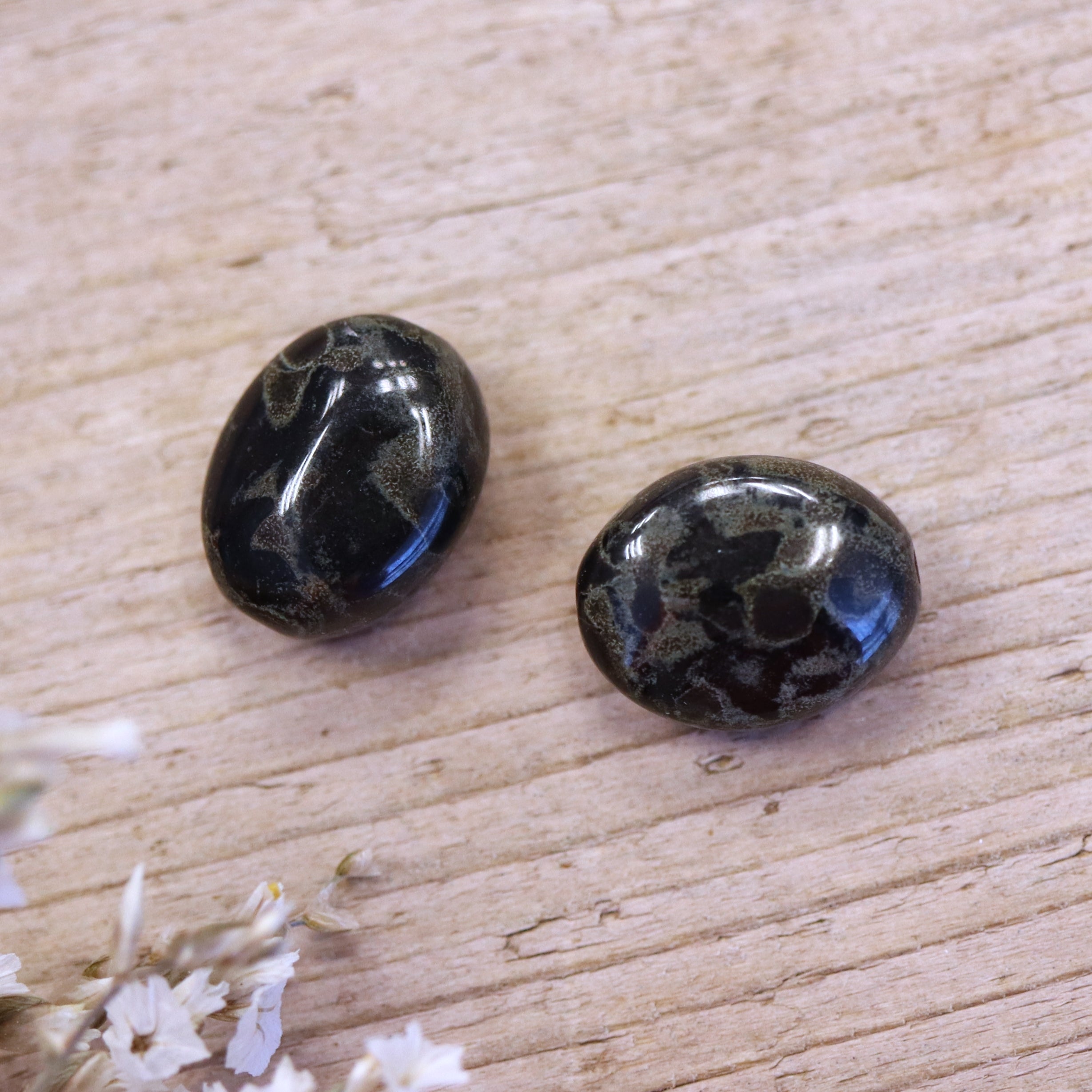 Perle schwarz - oval mit grünen Ölflecken